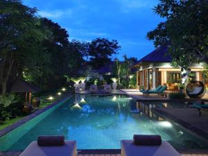 a swimming pool in a resort at night at The Shanti Residence by Elite Havens in Nusa Dua