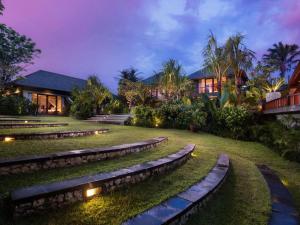 una casa con luces en el patio por la noche en The Shanti Residence by Elite Havens, en Nusa Dua