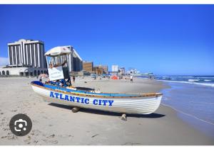 a boat sitting on the beach next to the ocean at Rustic Redlion Home 