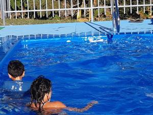 un niño y una niña en una piscina en Cabañas Alto Caburgua 2 dorm, en Caburgua