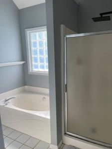 a bathroom with a bath tub and a window at Fortress of Solitude in Powder Springs