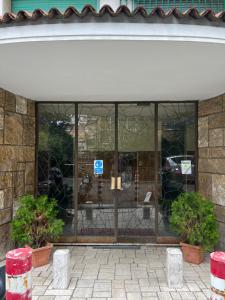 uma frente de loja com janelas de vidro e vasos de plantas em PARIOLI LUXURY HOME em Roma