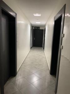 a hallway with black doors and a tile floor at EVO résidence in Oujda