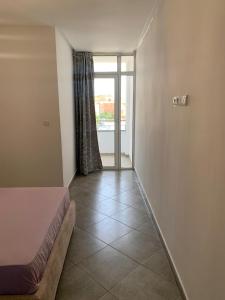 1 dormitorio con 1 cama y puerta de cristal con ventana en EVO résidence en Oujda