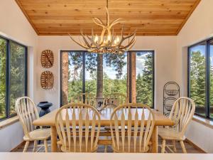 a dining room with a wooden table and chairs and windows at Moonlight Ridge in Duck Creek Village