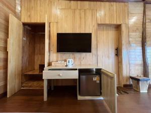 a kitchen with a desk with a tv on a wall at Palm Leaf Resort Koh Tao in Ko Tao +37 photos