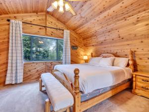 a log cabin bedroom with a bed and a window at Moonlight Ridge in Duck Creek Village