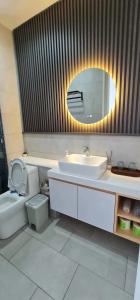 a bathroom with a sink and a toilet and a mirror at Summer Studio Apartment at Kota Kinabalu City Centre in Kota Kinabalu