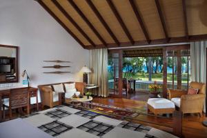 a living room with a couch and a table at The Oberoi Beach Resort, Lombok in Tanjung
