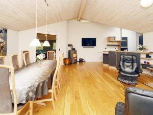 una sala de estar con una mesa larga y sillas en 10 person holiday home in R dby, en Rødby