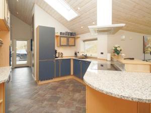 a large kitchen with blue cabinets and a counter top at 10 person holiday home in R dby in Rødby