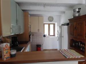 a kitchen with a white refrigerator and a window at Maison de caractère au coeur de la corse rurale in Calacuccia