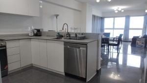 a kitchen with a sink and a dishwasher at Grand Bay Tower in Panama City