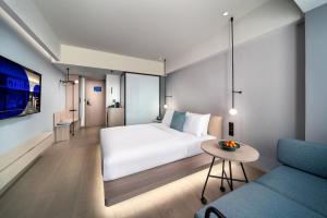 a hotel room with a bed and a couch at CYBO Station Luohu Shenzhen in Shenzhen