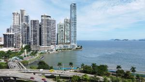 een stad met hoge gebouwen en een waterlichaam bij Grand Bay Tower in Panama-Stad