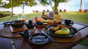 a wooden table with plates of food on it at The Oberoi Beach Resort, Lombok in Tanjung