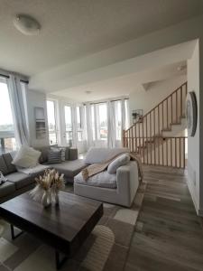a living room with a couch and a table at Beautiful, 4brd-3bthTownhome 7mins to Lakeshore in Barrie