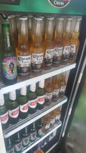 a refrigerator filled with lots of bottles of beer at Hospedaje Vegas in Tarapoto