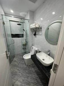 a bathroom with a sink and a toilet and a mirror at Lavender Sonasea Vân Đồn, Quảng Ninh in Quang Ninh