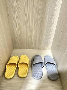 two pairs of shoes are sitting on a bed at Formosa Residence Nagoya, 2 Bedroom, Batam City in Nagoya