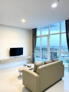 a living room with a couch and a large window at Formosa Residence Nagoya, 2 Bedroom, Batam City in Nagoya
