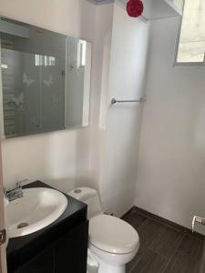 a bathroom with a white toilet and a sink at Apartamento vacacional Girardot, in Girardot +4 photos