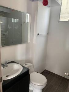 a bathroom with a white toilet and a sink at Apartamento vacacional Girardot, in Girardot