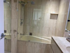 a bathroom with a bath tub and a sink at Contessa Holiday Apartments in Gold Coast