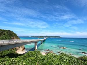 un puente sobre una playa junto al océano en KAMENOI HOTEL Setouchi Hikari, en Hikari