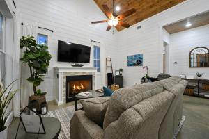 a living room with a couch and a fireplace at Bella Luna Cabin - Cozy Farmhouse Cabin, Private Deck, Swing Set, Fire Pit, Hot Tub in Broken Bow