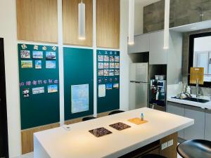 a kitchen with a blue wall with pictures on it at Penghu Good together Villa in Magong