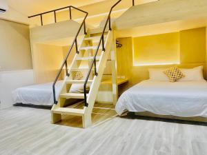 Litera en habitación con 2 camas y escalera en Penghu Good together Villa, en Magong