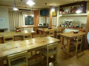 Taiya Ryokan في فوجي: غرفة طعام مع طاولات وكراسي خشبية