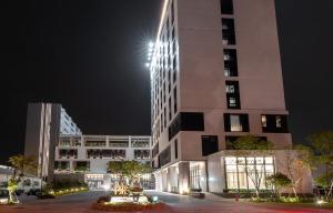 a tall building with lights on the side of it at Lai Hotel in Guiren