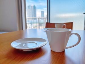 a cup and a plate on a wooden table at NALY. TENMA AFP Apartment in Osaka +62 photos