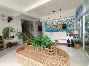 un vestíbulo con una gran mesa de mimbre con plantas. en Frachette's Bed & Breakfast en Puerto Princesa
