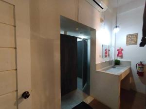 a bathroom with a black door and a sink at Frachette's Bed & Breakfast in Puerto Princesa City