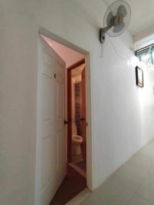 um corredor com uma porta que leva a um WC em Frachette's Bed & Breakfast em Puerto Princesa
