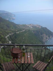 una mesa con copas de vino y una cesta en el balcón en Infinity view, en Vernazza