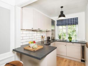 a kitchen with white cabinets and a black counter top at Frederikenhof in Kampen