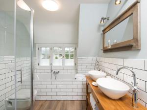 a bathroom with two sinks and a tub and a shower at Frederikenhof in Kampen