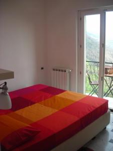 - un lit coloré dans une chambre avec fenêtre dans l'établissement Infinity view, à Vernazza