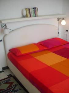 Una cama con sábanas multicolores encima. en Infinity view, en Vernazza