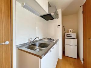 a small kitchen with a sink and a microwave at NALY. TENMA AFP Apartment in Osaka