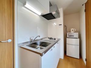 a small kitchen with a sink and a microwave at NALY. TENMA AFP Apartment in Osaka