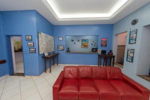 uma sala de estar com um sofá vermelho e paredes azuis em Goiânia Palace Hotel em Goiânia