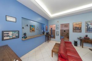 uma sala de estar com paredes azuis e um sofá vermelho em Goiânia Palace Hotel em Goiânia