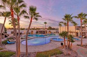 una piscina con palmeras en un complejo en New Built Condo minutes to Beach! en Puerto Peñasco