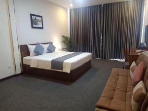 a hotel room with a bed and a couch at Nimith Hotel & Restaurant in Phnom Penh