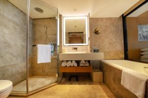 a bathroom with a sink and a tub and a toilet at Renaissance Beijing Wangfujing Hotel in Beijing